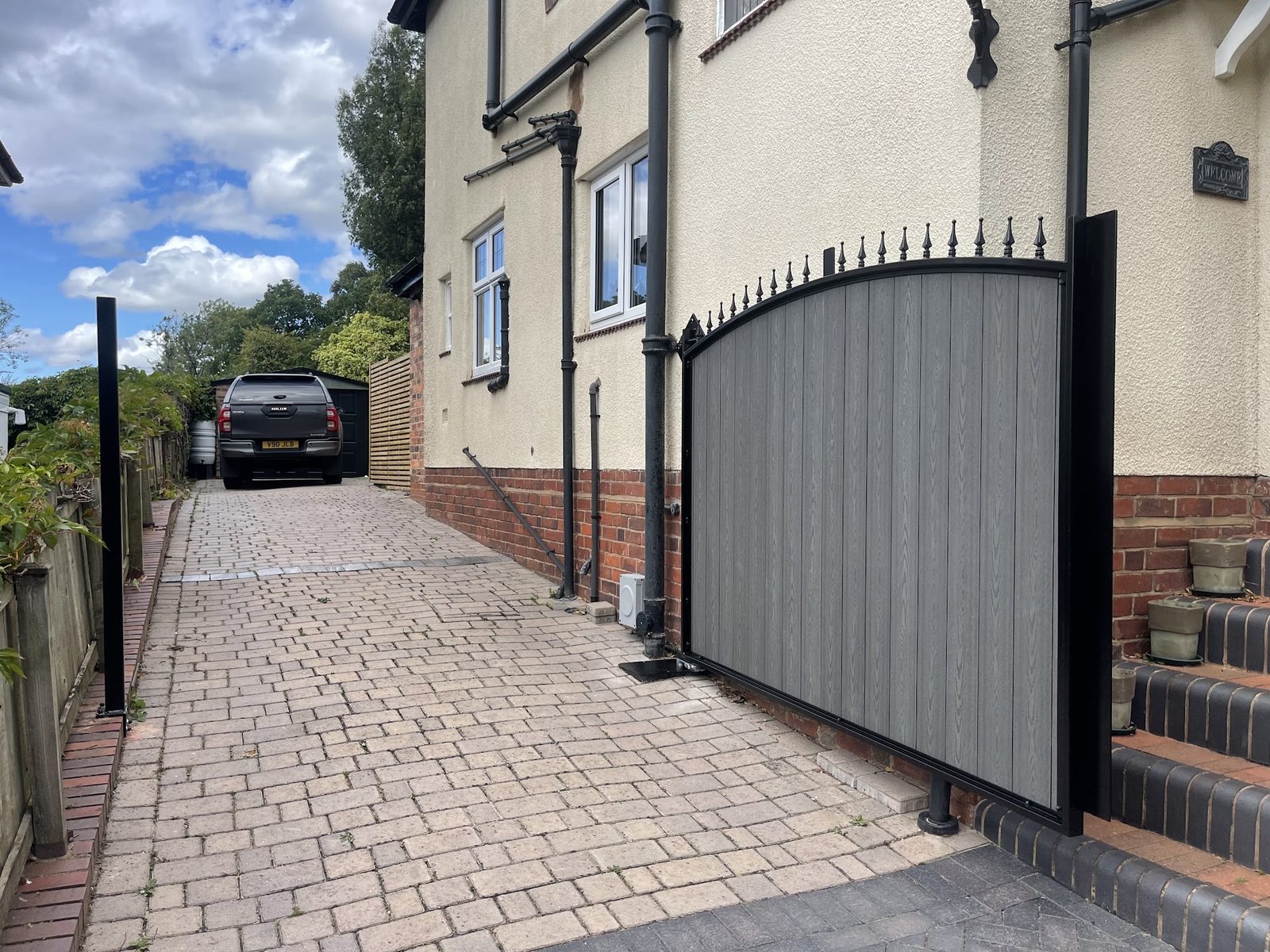 Side gate closing off a block paved driveway between houses